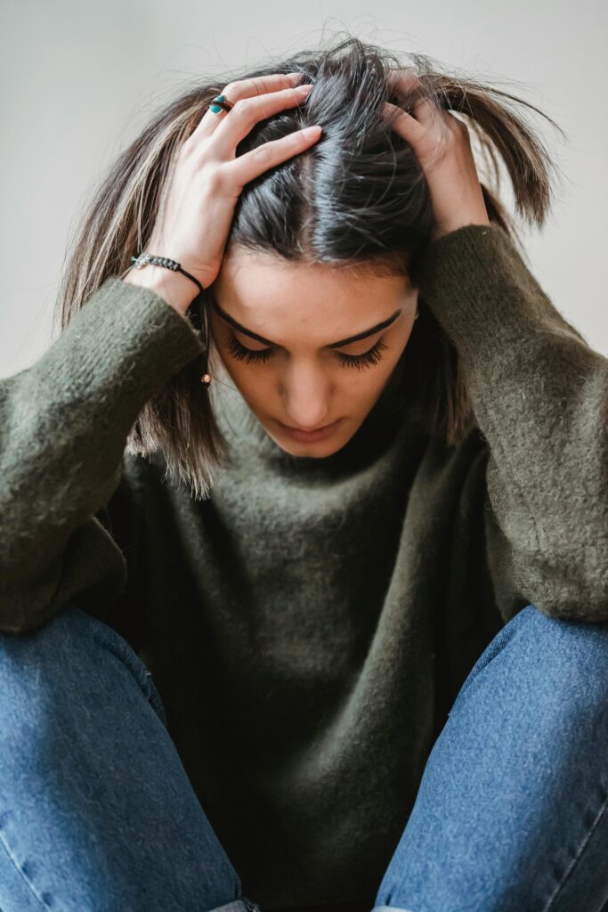Woman holding head in hands appearing stressed