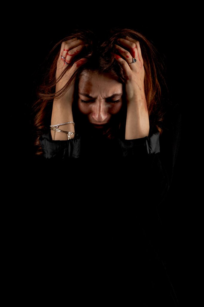 Woman in anguish holding head in hands
