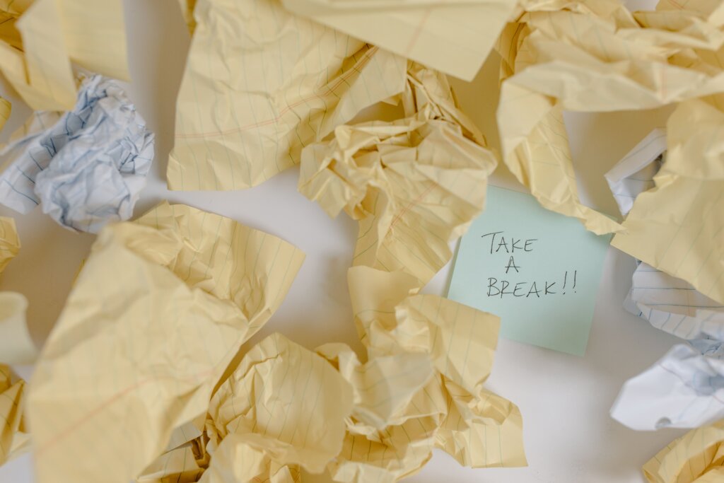 crumpled pieces of pager with sticky note in middle saying take a break!