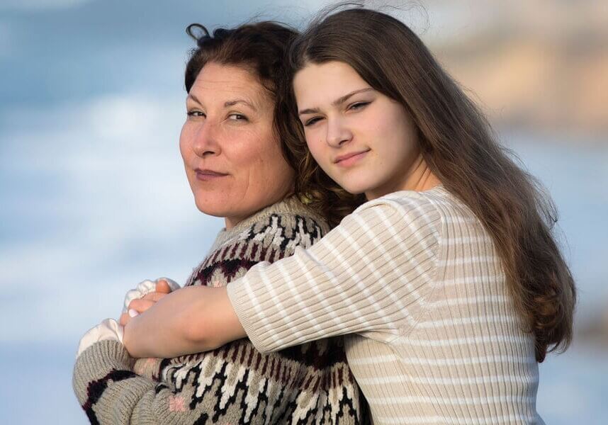 A teen hugging her mother