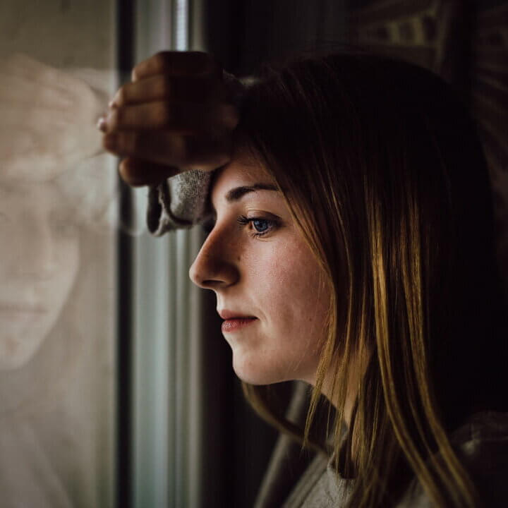 a woman thinking and looking out her window
